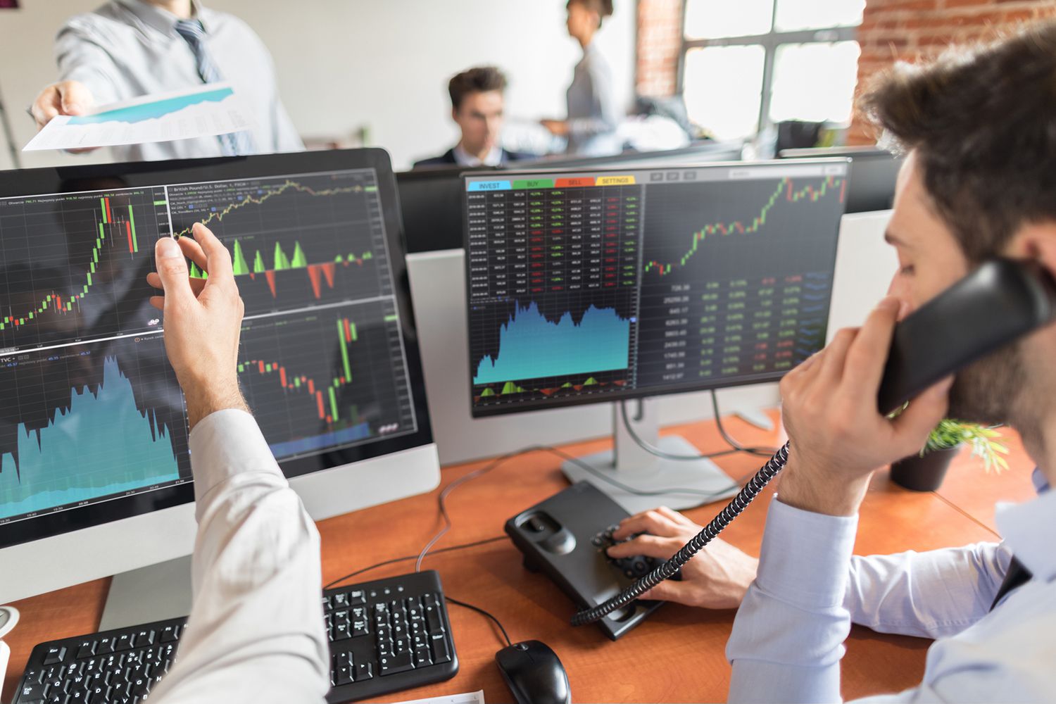Picture of traders analyzing charts on computers
